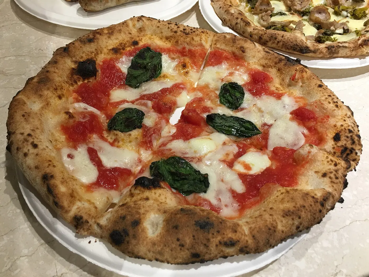 Pizza margherita z bazylią na stole